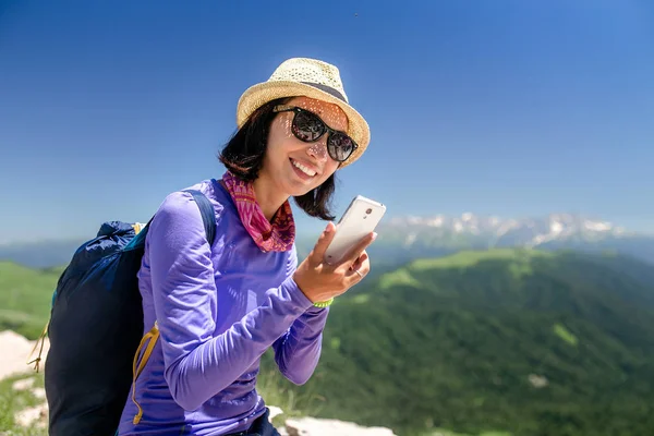 Жінка мандрівник у горах розмовляє на смартфоні під час походу — стокове фото