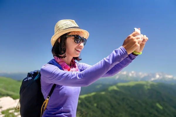 Viajero mujer en las montañas hace selfie en teléfono inteligente — Foto de Stock