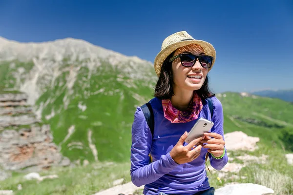A hegyekben, egy túra során egy smartphone beszélő nő utazó — Stock Fotó