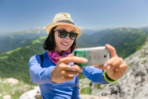 Жінка мандрівник у горах робить селфі на смартфоні — стокове фото