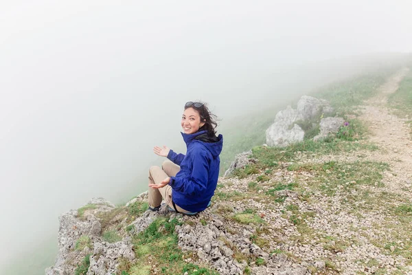 Mladá šťastná žena těší pohled skvělá zamlžené krajiny na vrchol hory — Stock fotografie