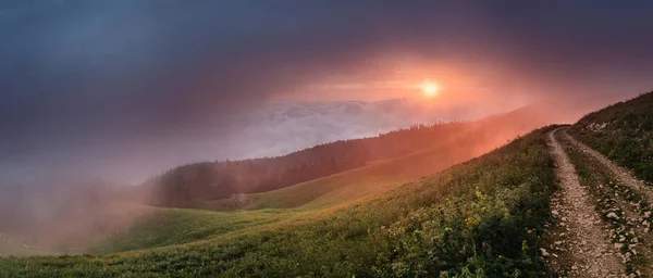 Toprak yol dağlara sis ya da bulut ile büyük günbatımı Panoramalı Oda — Stok fotoğraf
