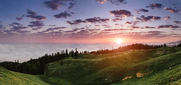 Hermoso atardecer en las montañas con niebla y nubes y pequeñas casas pastores — Foto de Stock