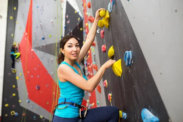 Fit mulher esportiva olhando para a parede de escalada na academia e treinamento — Fotografia de Stock