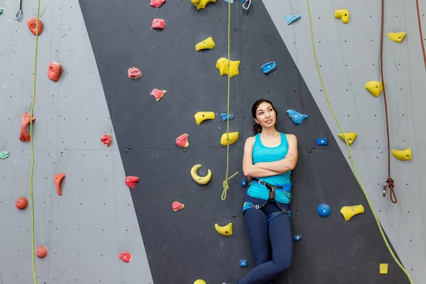 Woman coach boulder stands near climbing wall and looking at the camera — Stock Photo, Image