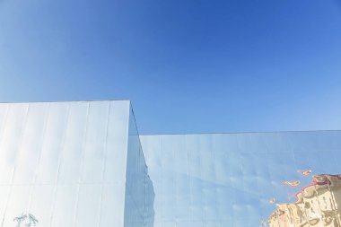 Ayna metalik duvarlar ve mavi gökyüzü ile modern yapı