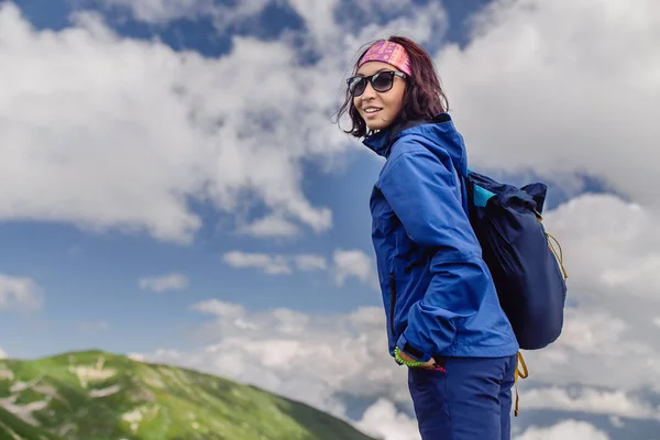 Senderismo mujer asiática feliz y sonriente durante el trekking en prados alpinos en las montañas — Foto de Stock