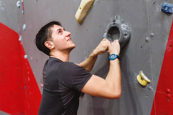 Homem escalando parede de rocha no ginásio dentro de casa — Fotografia de Stock