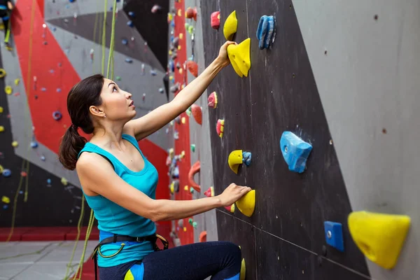 Fit mulher esportiva olhando para a parede de escalada na academia e treinamento — Fotografia de Stock