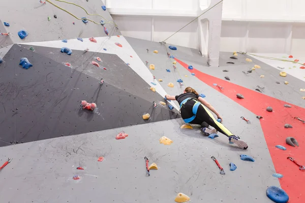 Femme sportive concentrée escalade le mur à la salle de gym intérieure — Photo