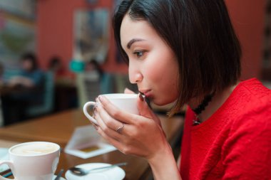 Asyalı kadın içecek bir fincan çay ya da kahve Cafe