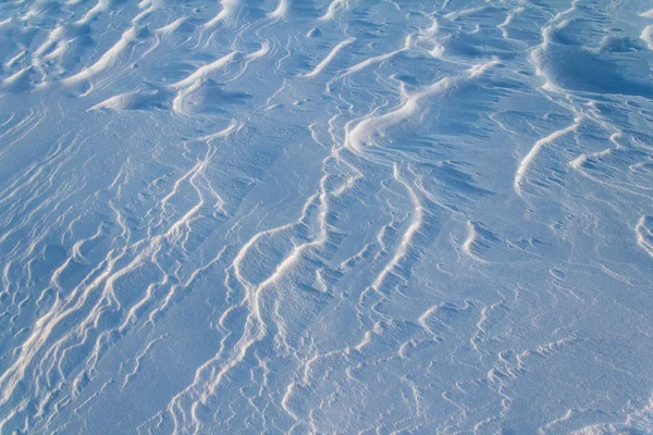 Υφή των μοτίβων dune χιόνι σε μια ηλιόλουστη ημέρα στη φωτιζόμενη — Φωτογραφία Αρχείου