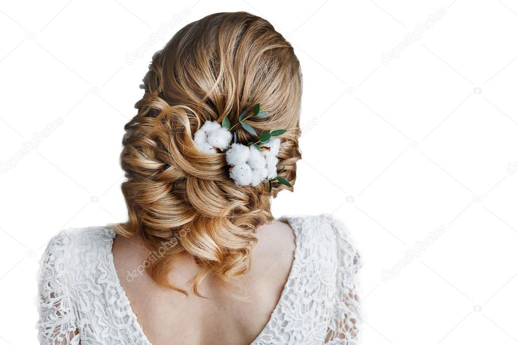 Portrait of attractive young woman with beautiful bridal hairstyle and stylish hair accessory of cotton flower isolated on white