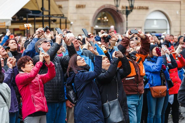 Prague, Cseh Köztársaság - 2017. március 18.: egy multinacionális nagy tömeg, a turisták fényképet okostelefonokon, és nézz fel a város jelképe — Stock Fotó