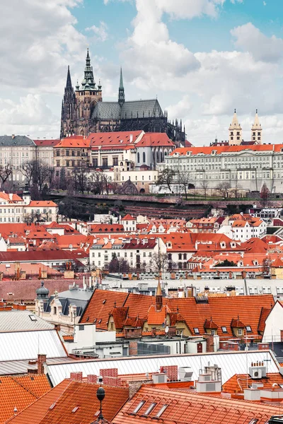 Teleobjektiv utsikt över Pragborgen med St. Vitus rotundra, omgiven av orange tegeltak av hus — Stockfoto