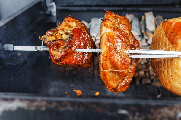 Un grand morceau de jambon de porc est cuit sur un feu ouvert dans le gril. Rue nourriture tchèque — Photo