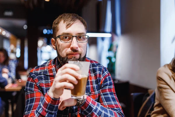 Bokovky muž v brýlích je pití kávy v kavárně — Stock fotografie