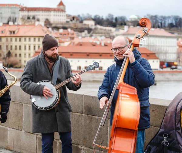 Prague, Çek Cumhuriyeti - 18 Mart, 2017: Street band müzisyen Charles Köprüsü'nde Prag'ın merkezi çello, saksafon ve banjo oynamak — Stok fotoğraf