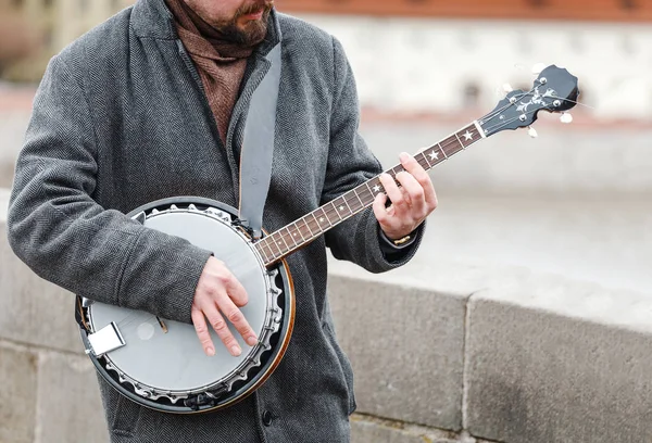 Un músico callejero tocando un banjo al aire libre —  Fotos de Stock