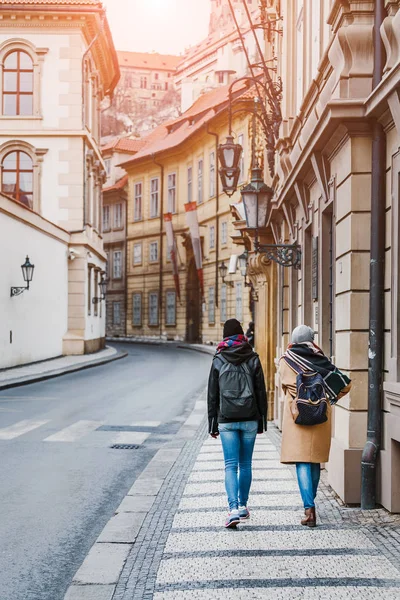 Duas jovens mulheres caminhando no centro histórico de Praga juntas, vista traseira — Fotografia de Stock