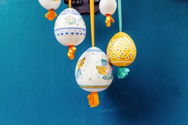 Güzel renkli Paskalya yumurtaları yay üzerinde mavi arka plan ile süslenmiş şeritler asılı