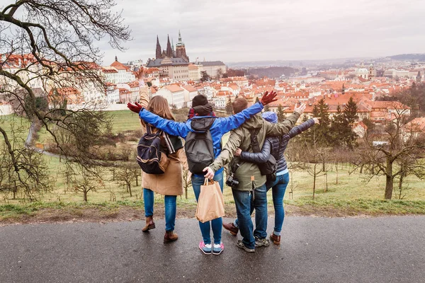 Back view of group of people hugging in Prague park at spring. Travel with friends concept — Stock Photo, Image