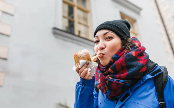 Женщина с аппетитом ест традиционную чешскую сладость Трделник или Трдло на улице Праги — стоковое фото