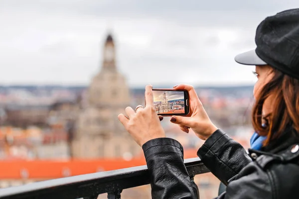Mujer joven tomando una foto en su teléfono inteligente de una ciudad de Dresde con punto de referencia Frauenkirche —  Fotos de Stock