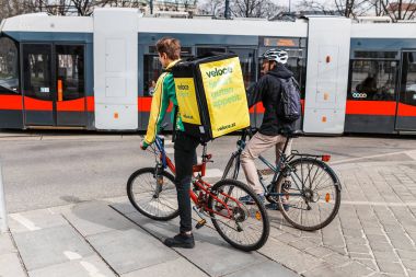 23 Mart 2017, Avusturya, Viyana: bisikletçi büyük sırt çantası ile bir pizza yemek dağıtım şirketinden şehir sokaklarında