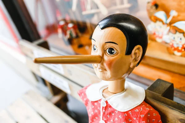 土産物店で彼の長い鼻を持つ木製のピノキオ人形 — ストック写真