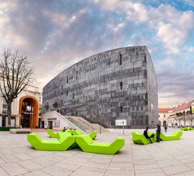 24 MARCH 2017, VIENNA, AUSTRIA: The square of the museum quarter in Vienna is a center of modern art with bright green benches clipart