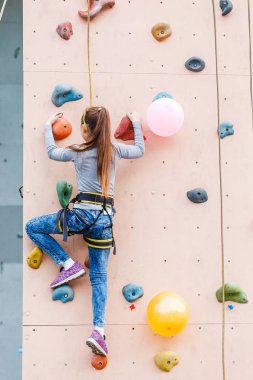 Ücretsiz spor salonunda, yapay kaya kaya duvarı üzerinde çalışmaya dağcı çocuk bouldering