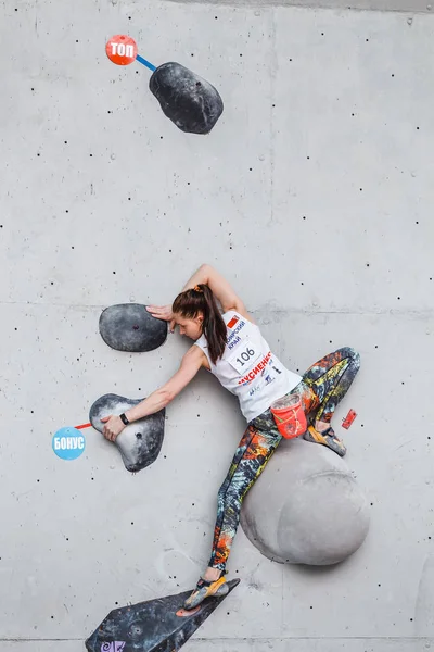 MAY 2017, UFA, RUSSIA, FINAL IN CLIMBING CHAMPIONSHIP: A female cligger participates in bouldering competitions at outdoors climbing gym and shows great technique and strength — стоковое фото
