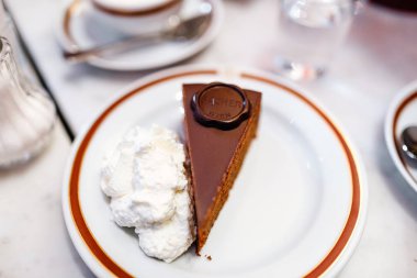 24 Şubat 2017, Viyana, Avusturya: orijinal otantik Viyana Sacher Torte pastayı servis ile krem şanti ve kahve Sacher Hotel Cafe