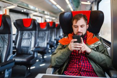 Bir sakallı bir hipster adam bir akıllı telefon, wifi Internet kavramı ve seyahat dolaşım bağlantısı ile çalışma