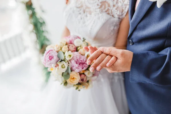 신랑 신부는 포옹을 하고 파스텔 꽃으로 결혼식 부케를 들고 있다. — 스톡 사진