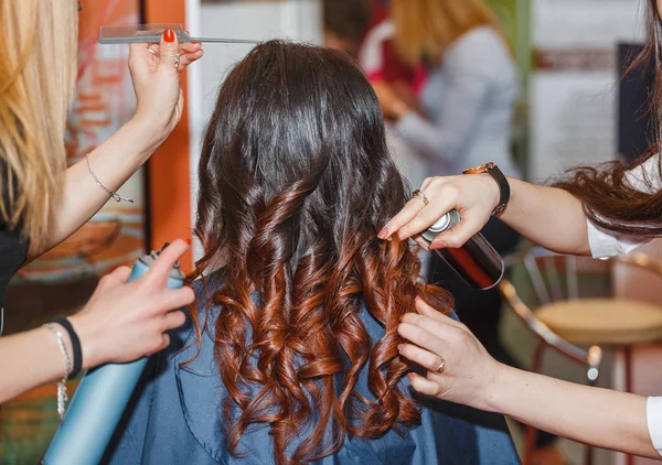 美容院で巻き毛の髪型を作る髪スプレーと女性の頭とスタイリスト手のクローズ アップ — ストック写真