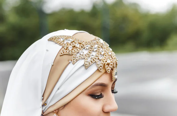 Азиатская мусульманская невеста в белом, украшенная золотым арабским ювелирным хиджабом и шарфом, концепция восточной свадьбы — стоковое фото