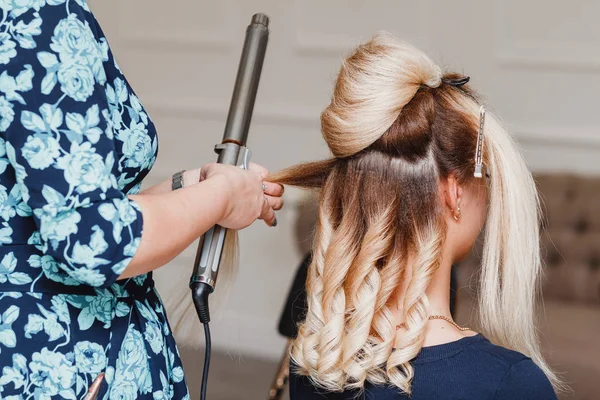 Cabeleireiro mulher fazendo penteado no salão de beleza usando curler ferro — Fotografia de Stock