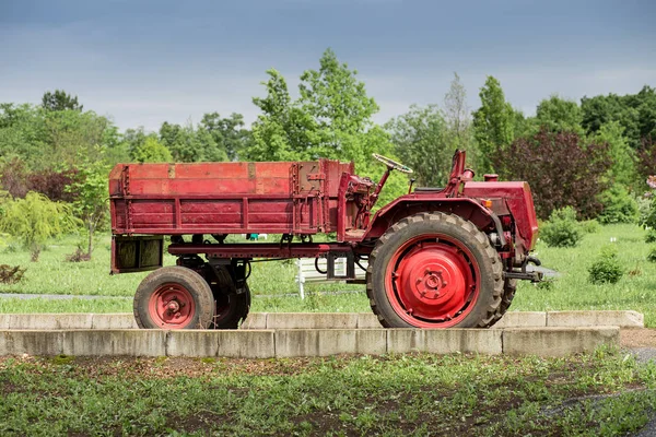 Red tractor parked in garden, agricultural and rural concept