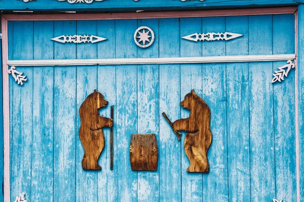 Autentické venkovských dřevěný dům v obci s vyřezávanými brána fasádní dekorace — Stock fotografie