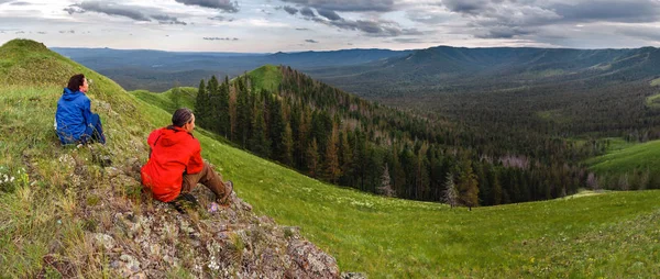 Turisté turistům relaxaci na vrcholu hory a pokochat se výhledem z horských údolí — Stock fotografie