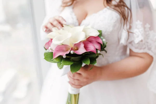 特写镜头的新娘紧握着与鲜花马蹄莲的婚礼花束 — 图库照片