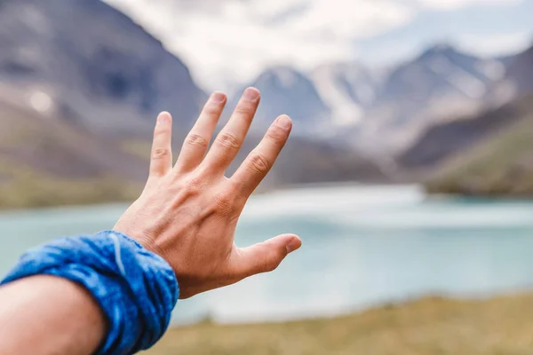 La mano está tratando de llegar al lago de montaña, concepto de viaje — Foto de Stock