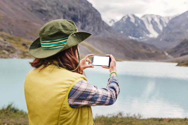 Nő természetjáró bevétel fénykép-ból egy hegyi tó rá smartphone — Stock Fotó