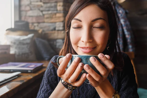 Une belle femme asiatique buvant du café chaud ou du thé à partir d'une tasse vintage dans un café loft moderne — Photo