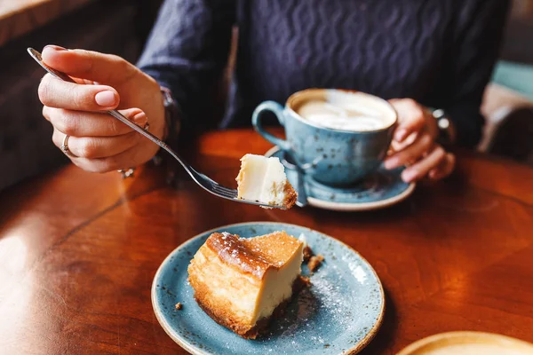 Mujer comiendo tartas de queso con cuchara en la cafetería —  Fotos de Stock