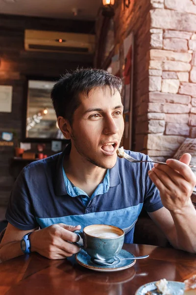 Mladý muž si kávu s hračkou v kavárně — Stock fotografie