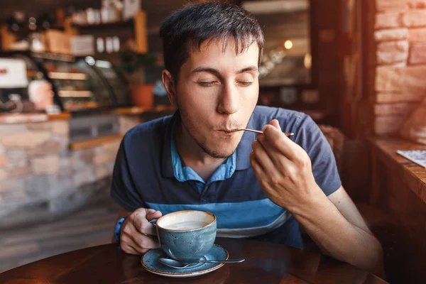 Młody człowiek Kawa korzystających z kawałkiem ciasta w kawiarni — Zdjęcie stockowe