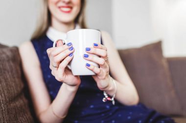 Bir fincan sıcak kahve evde tutan bir kadın elinde yakın çekim
